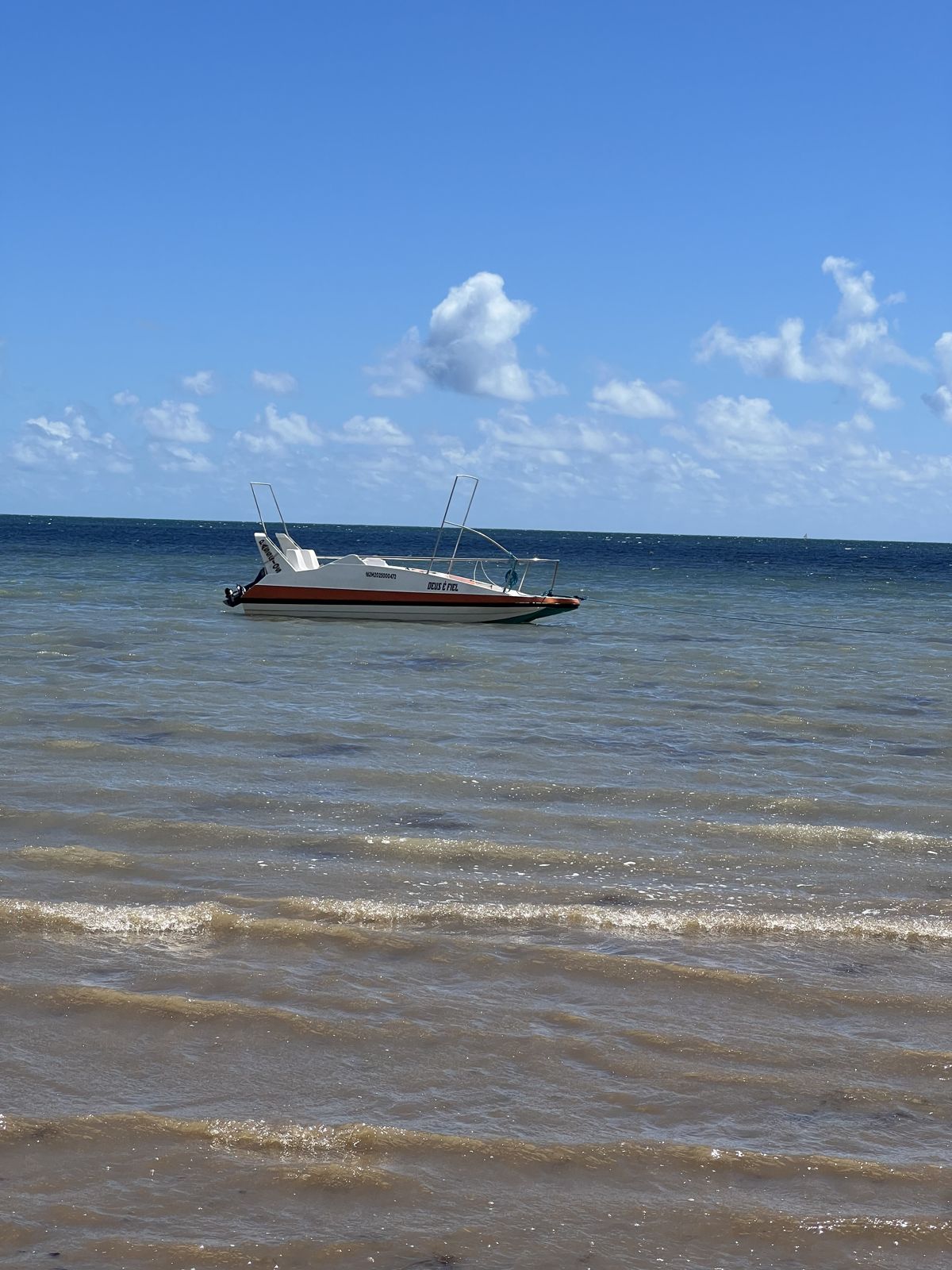 Lancha ancorada nas águas turquesa da praia