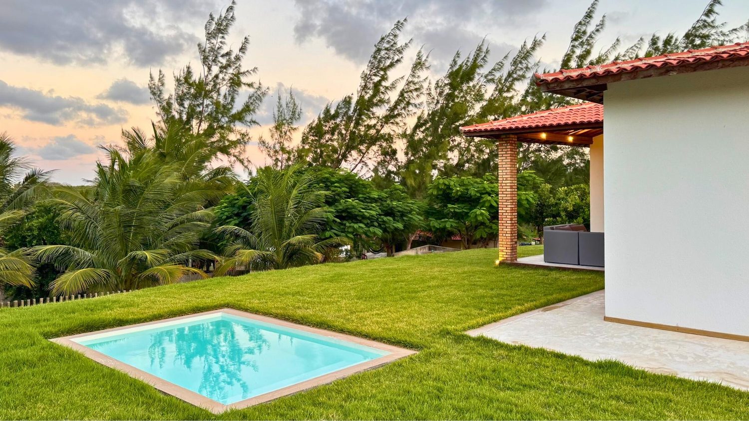 Piscina da Coast House com jardim e pergolado