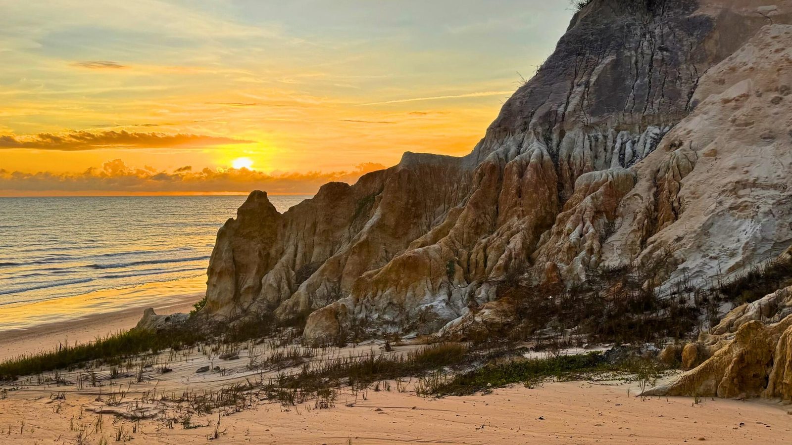 Praia do Retirinho ao pôr do sol com falésias